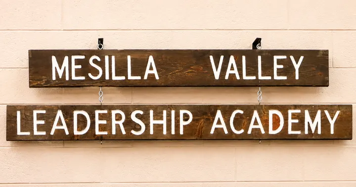Wooden signs reading “Mesilla Valley Leadership Academy” hang on a light-colored wall inside the Las Cruces school.