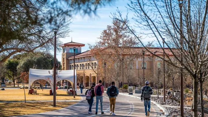 Students walk on the New Mexico State University campus in Las Cruces. The university is launching a systemwide mentorship program for undergraduates.