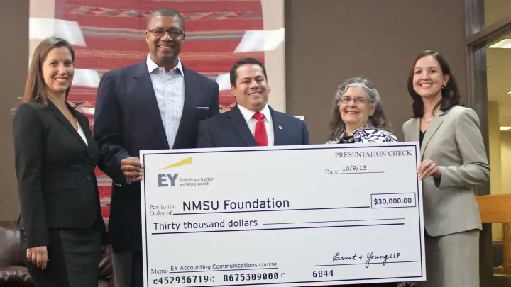 Five people pose with an oversized $30,000 presentation check made out to the NMSU Foundation during a 2013 donation presentation.