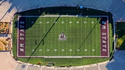Aerial view of Aggie Memorial Stadium at New Mexico State University, with the football field and surrounding grandstands visible.
