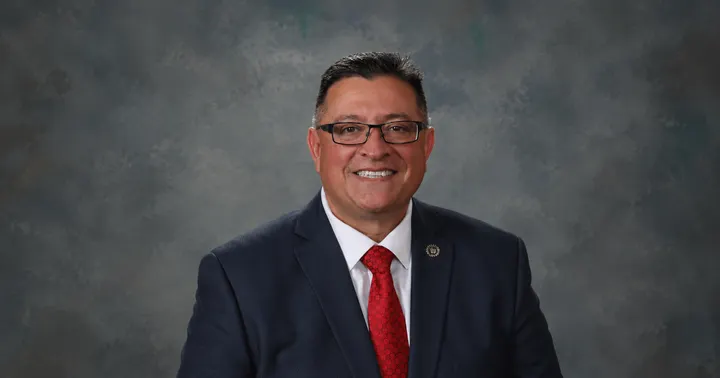 State Sen. Gabriel Ramos, R-Silver City, poses for an official portrait wearing a dark suit and red tie.