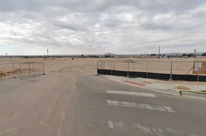 Construction fencing surrounds vacant land along Samaritan Drive at the proposed Royal Crossing affordable housing site in Las Cruces.