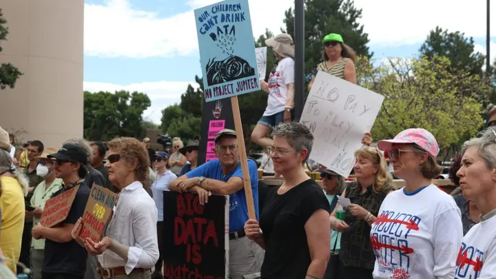 New Mexico residents hold protest signs during an Aug. 21, 2026, demonstration over Project Jupiter’s pending air quality permit.