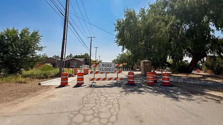 Barricades, traffic barrels and a “Road Closed” sign block a residential street near the Sunland Park-El Paso boundary.