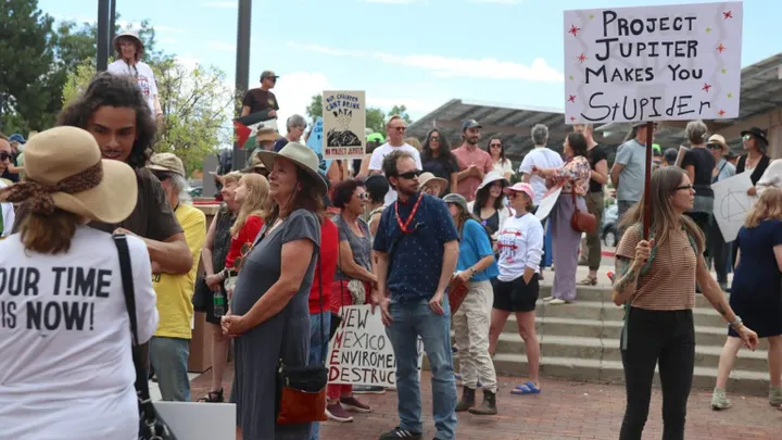 Demonstrators gather outside the New Mexico Environment Department in Santa Fe on Aug. 21, 2026, holding signs opposing Project Jupiter's proposed data center.