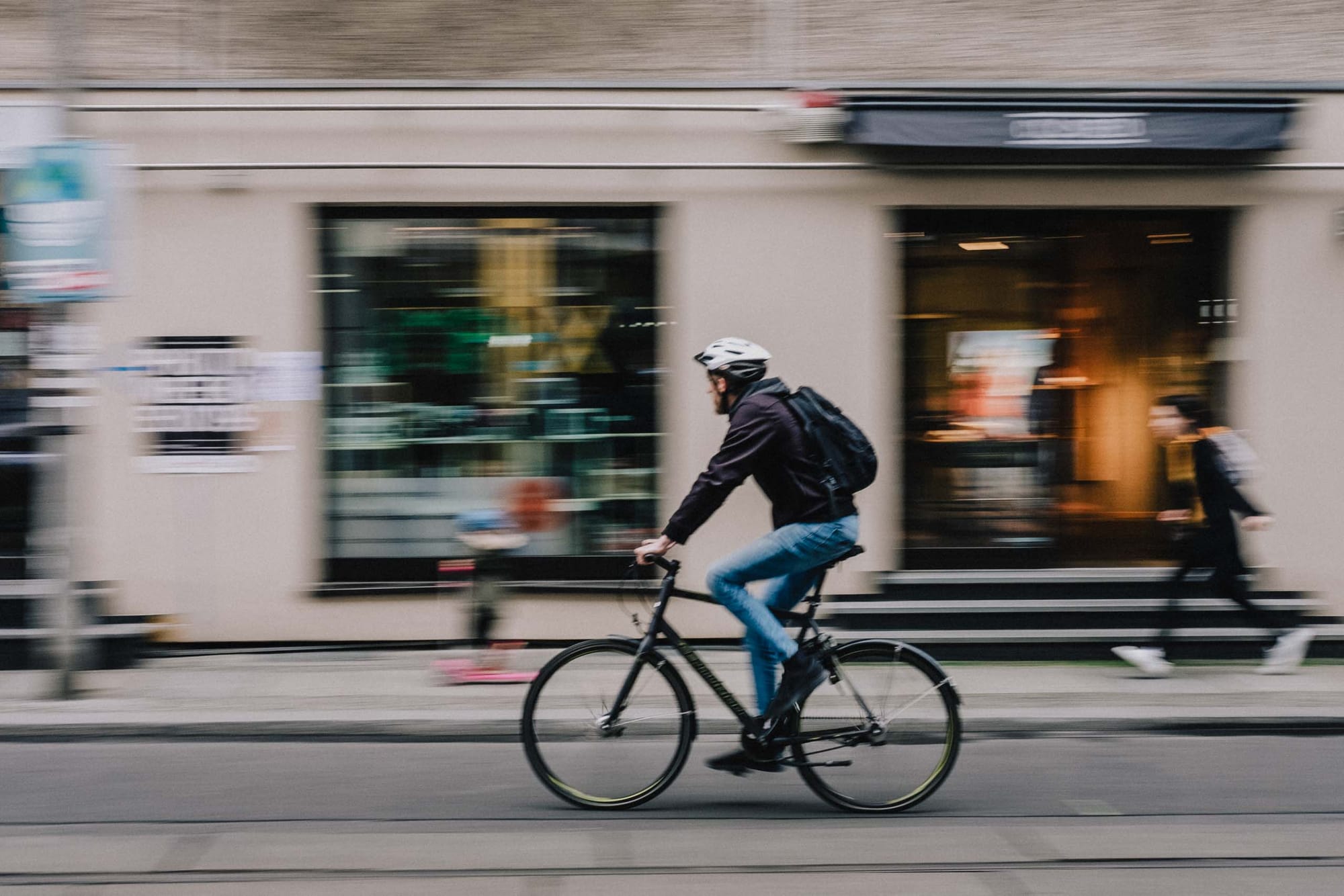 Cyclist moving through a city street with motion blur photographed with the Fujifilm XF35mm f2