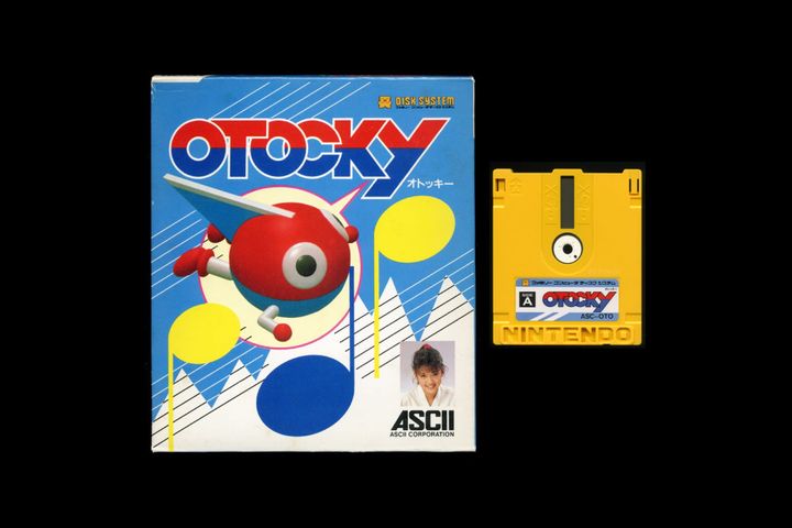 A photo shows Otocky's packaging art, with the game's main character on a blue background, alongside a copy of the Famicom Disk System game.