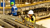 Factory workers inspecting bottled beverages on an automated production line at an East African Breweries facility.