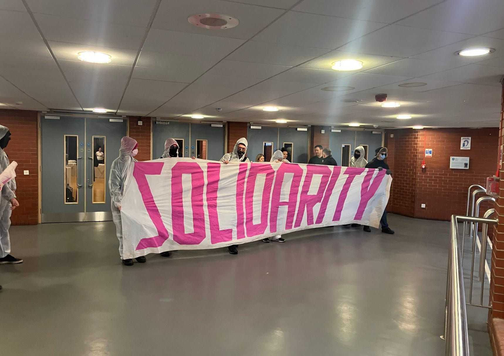 Two university students held up a banner - now they’re banned from campus