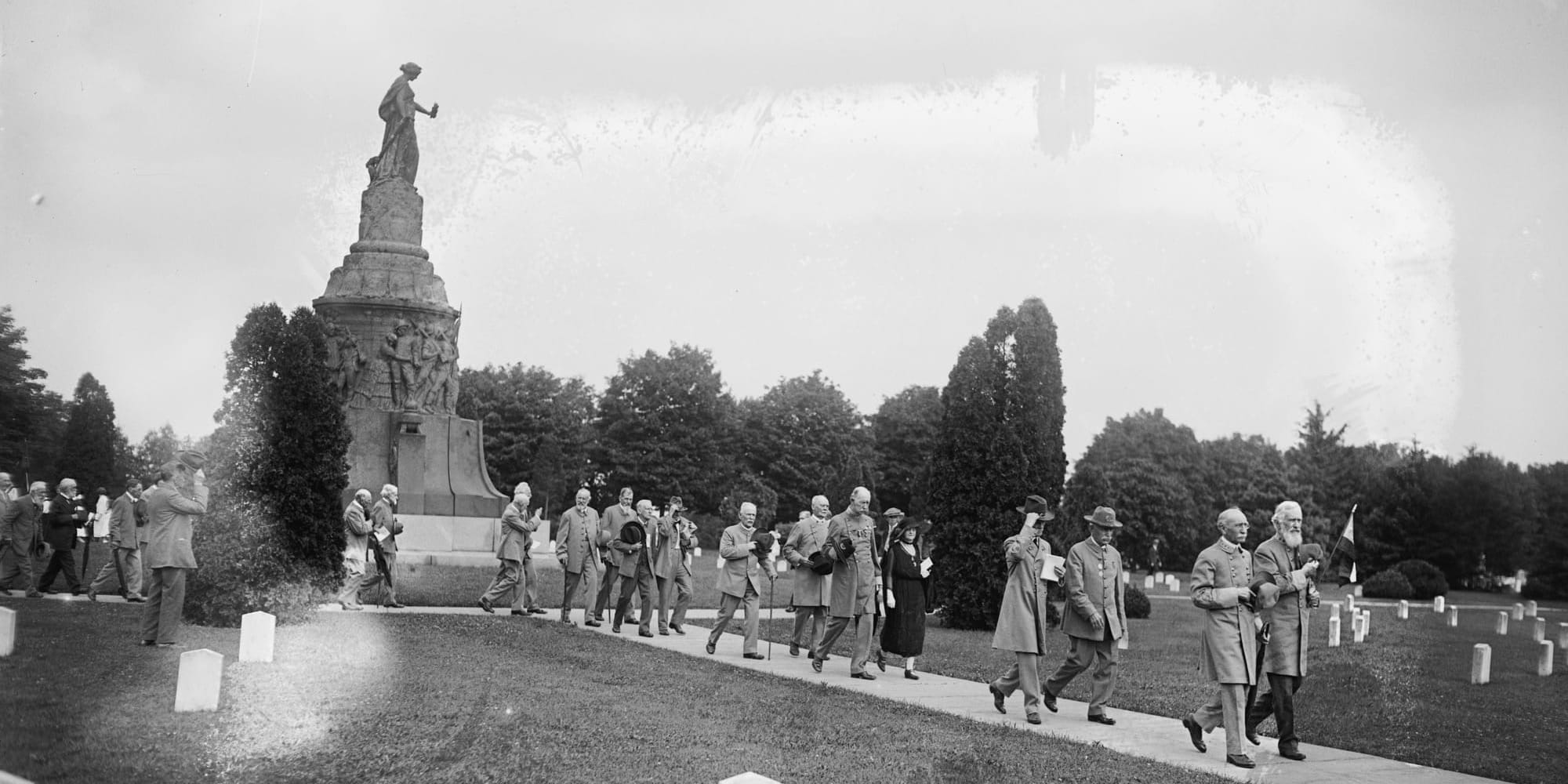 Men in gray walk away from the Arlington Confederate Monument at its deci
