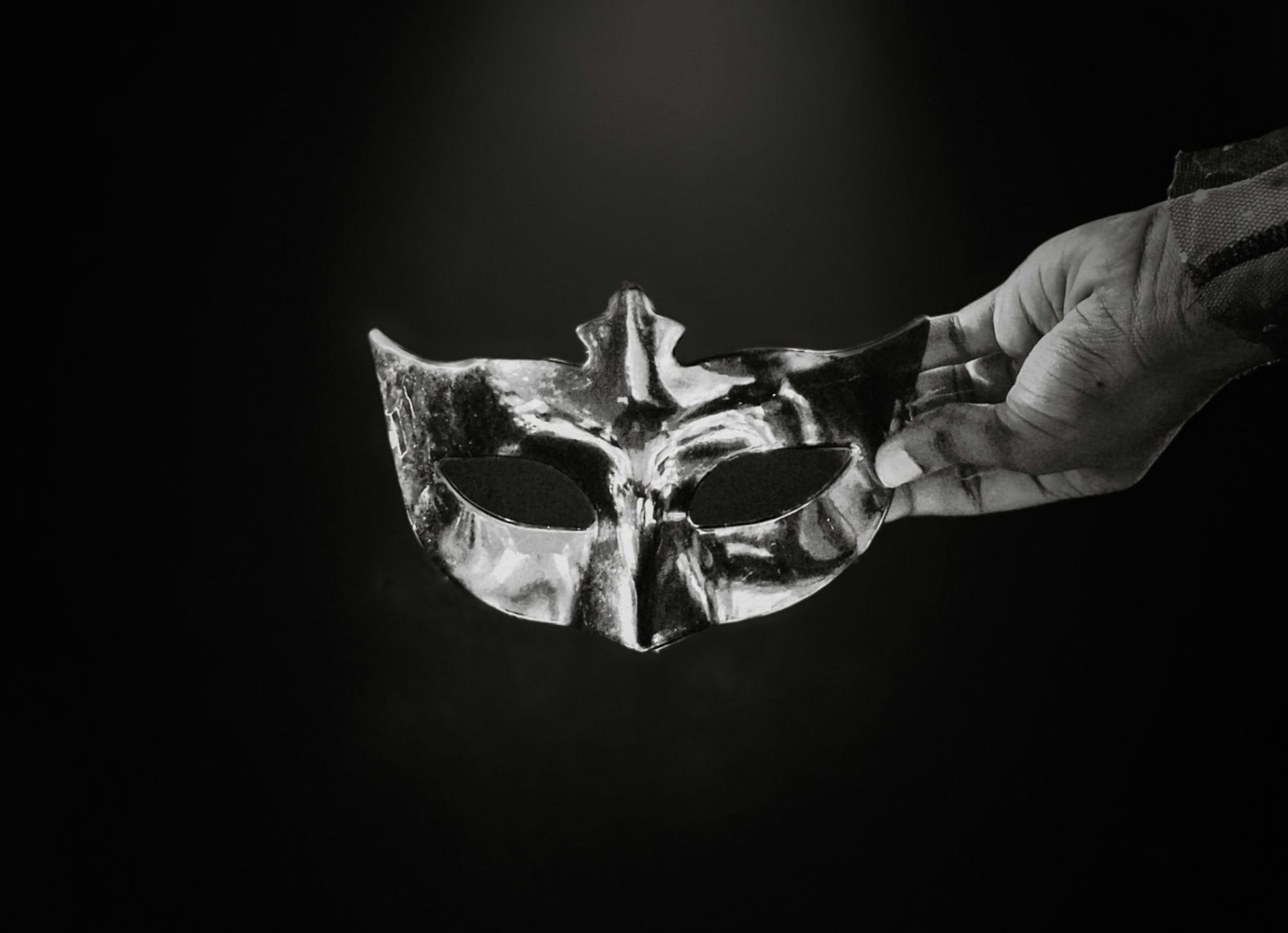 A black and white photo of a person holding a mask