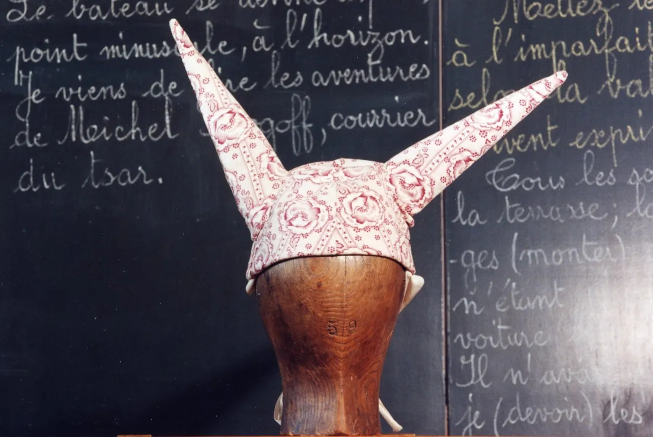 French classroom painting showing a child wearing a dunce cap, 1880