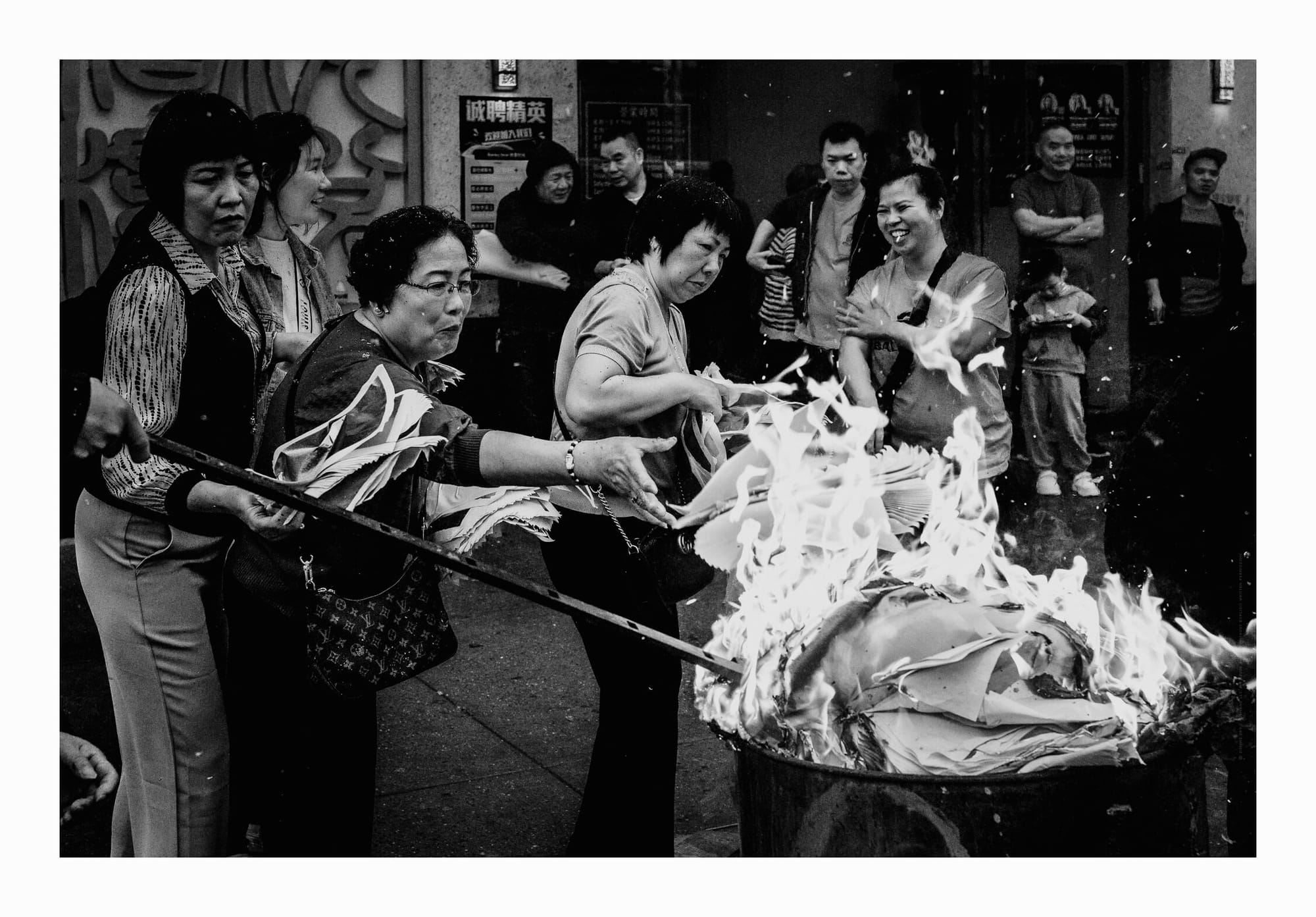 People burning paper, metal barrel, crowd, Brooklyn, Chinatown, black and white fine art photo.