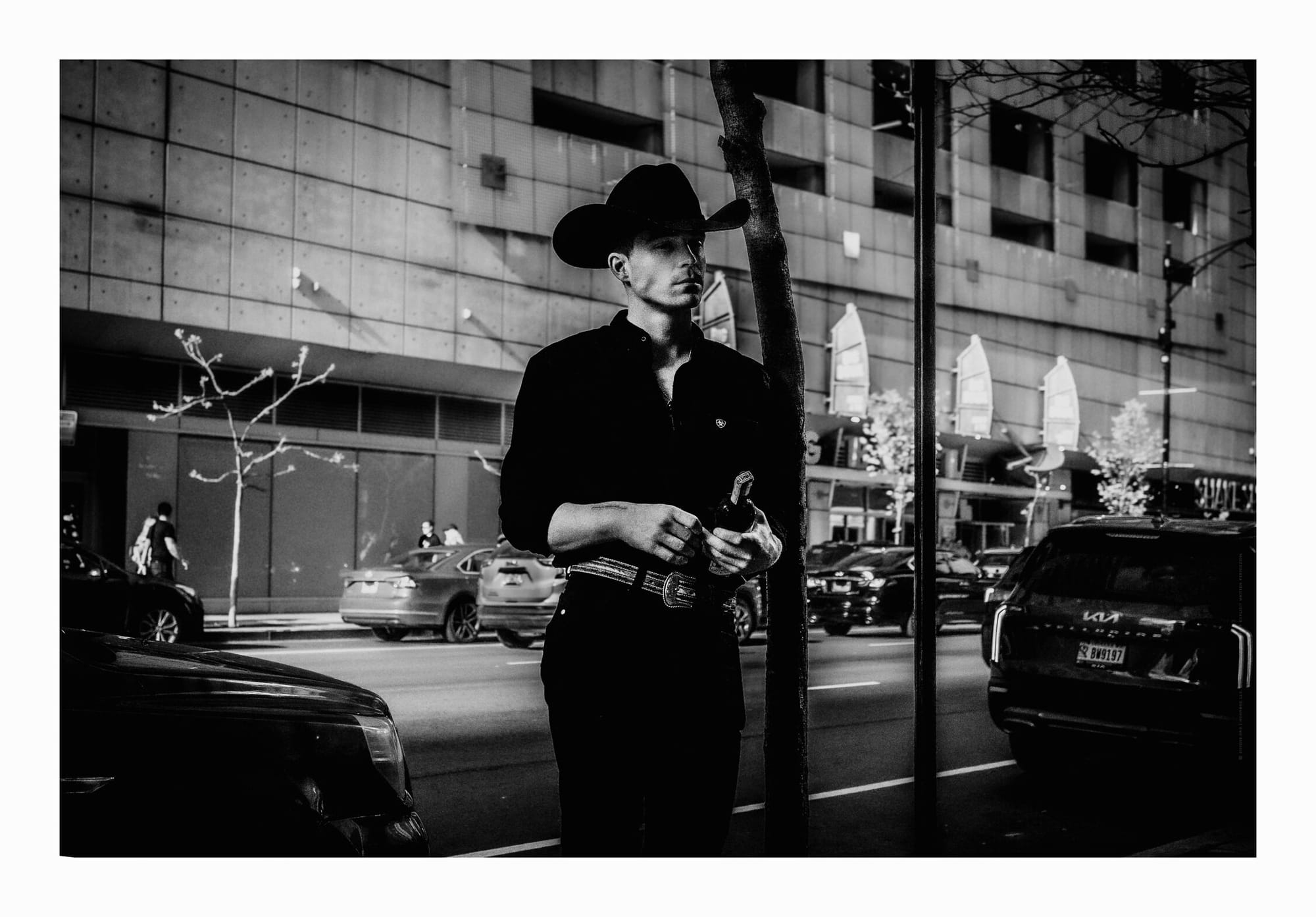 black dress cowboy holding bottle of wine downtown Chicago black and white fine art photo.
