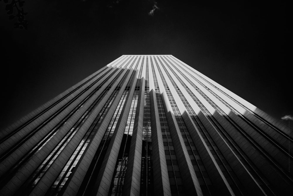 Dramatic low angle view Aon Center in Chicago. Light on top resembling snow like Mount Fuji black and white fine art photo.