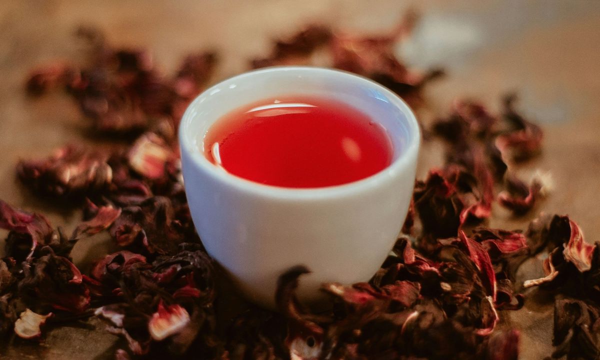A white cup of deep red hibiscus tea