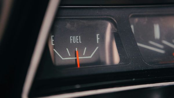 Close-up of a vintage car fuel gauge with the needle reading low