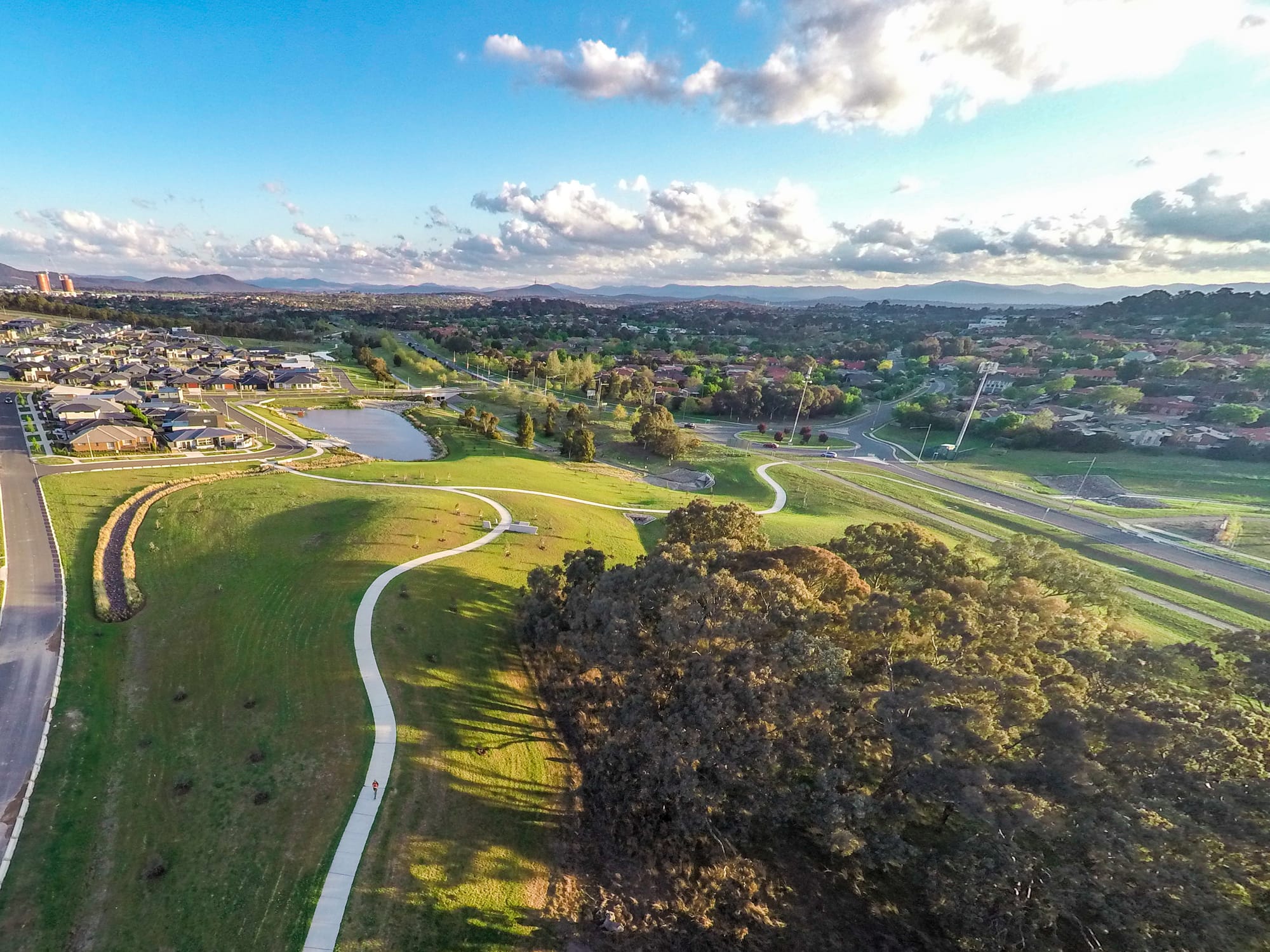 Aerial view of curving paths, open lawns and retained trees within Moncrieff East.