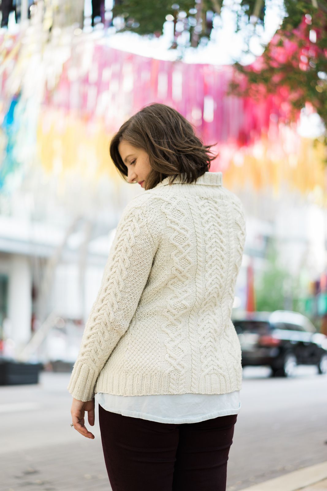 Christina in a cream-colored handknit cabled cardigan