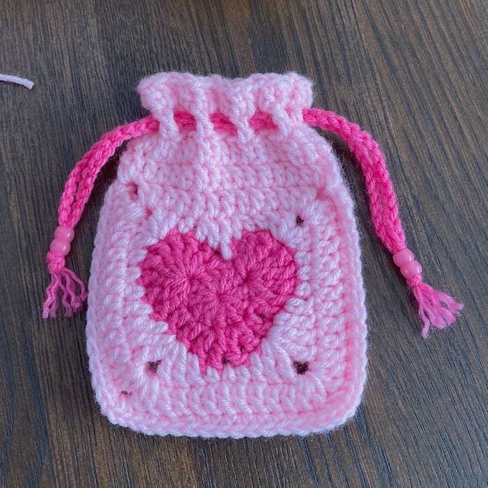 small light pink crocheted granny square pouch with bright pink center