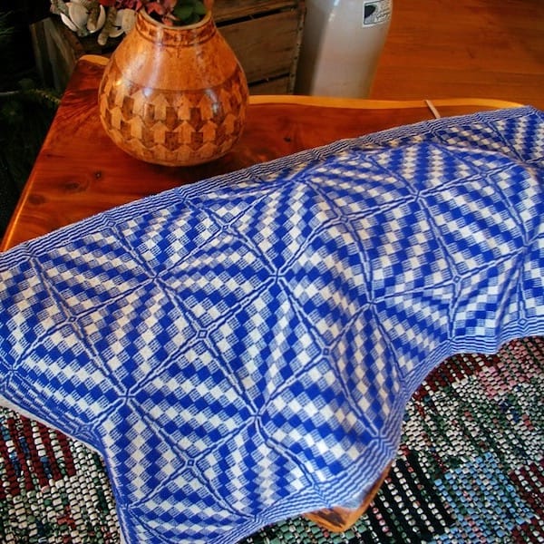 a bold graphic diamond patterned blue and white table runner strewn on a table