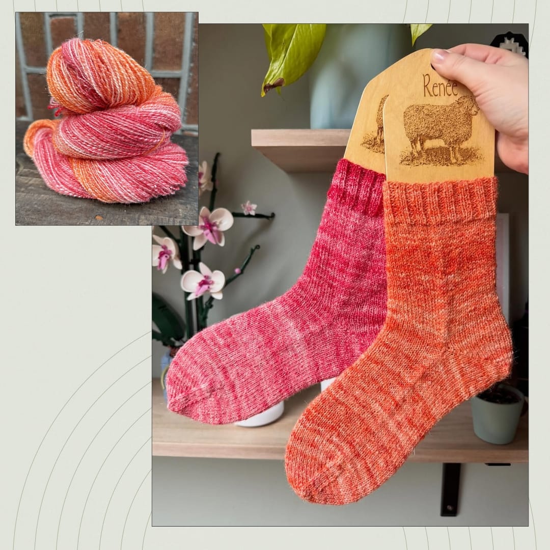 Finished handknit socks displayed on sock blockers next to the handspun yarn used to make them.