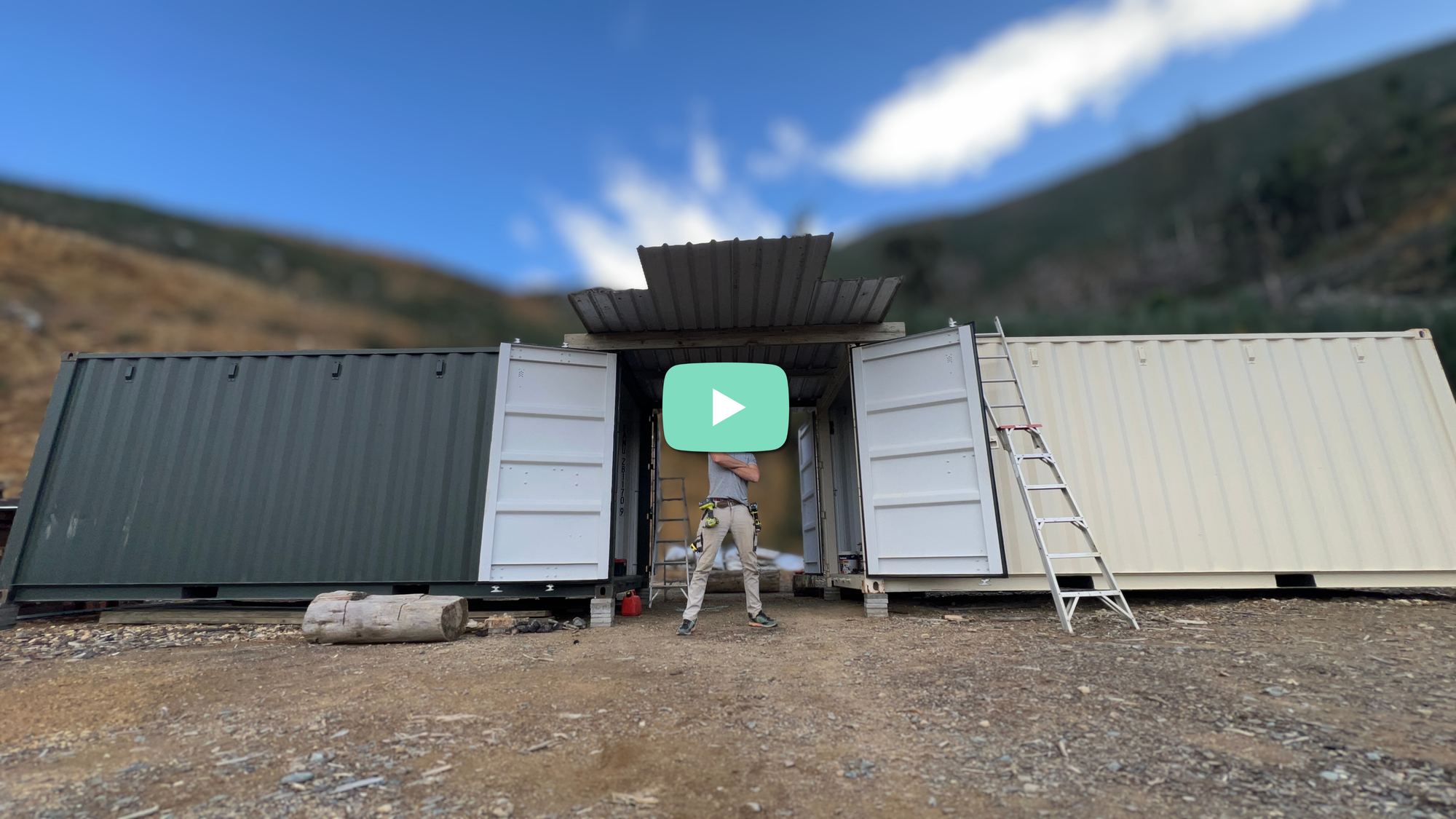 Xander standing in front of the two containers WITH a roof