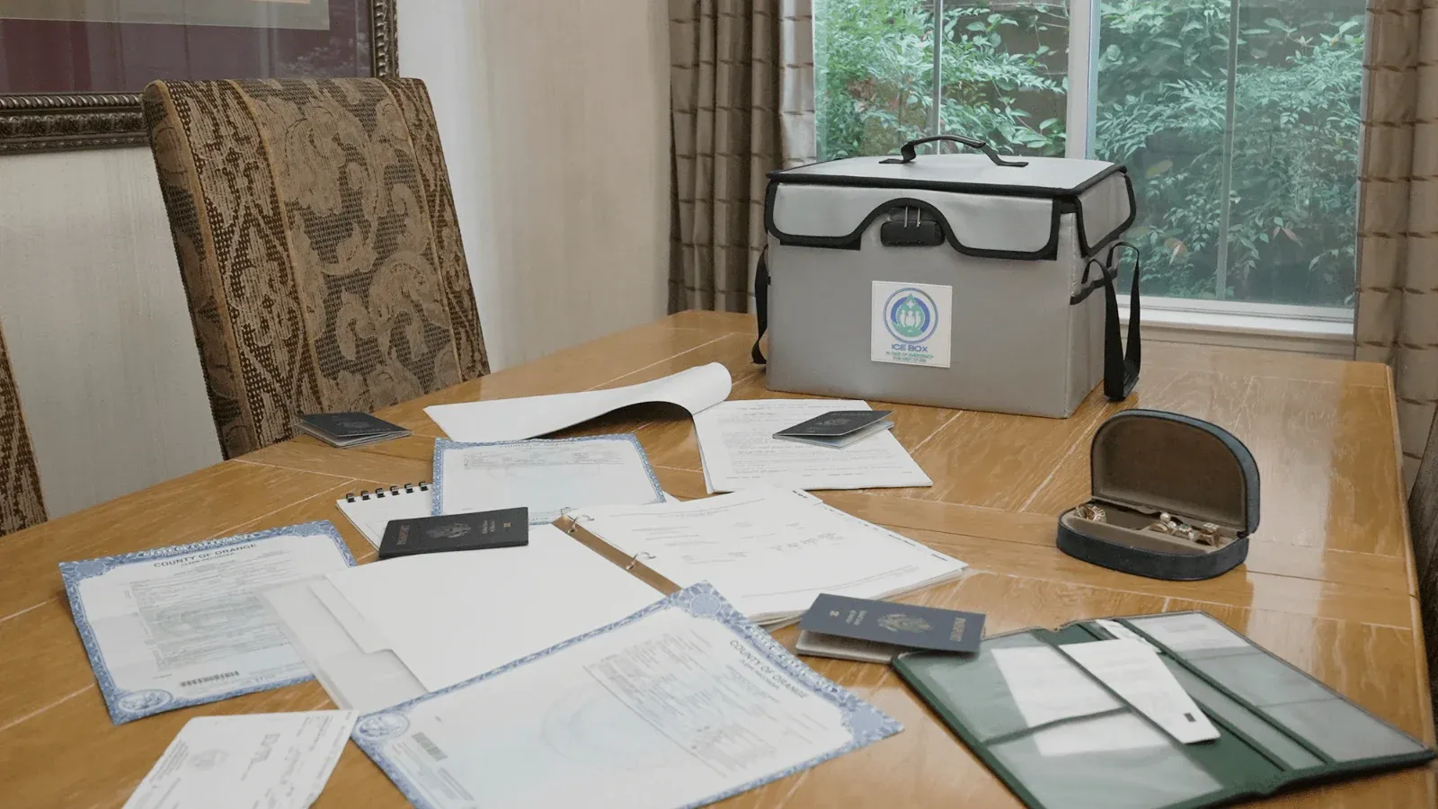 the Ice Box sitting on a table with important documents including passports and life insurance