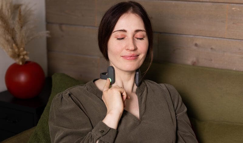 Calm woman using Pulsetto for panic attack, therapy for anxiety and depression