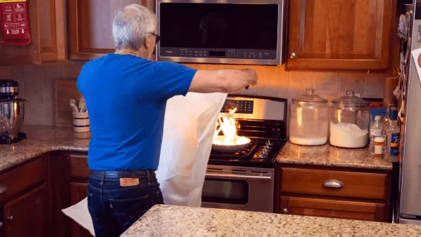 man uses mylar blanket to extinguish fire in pan