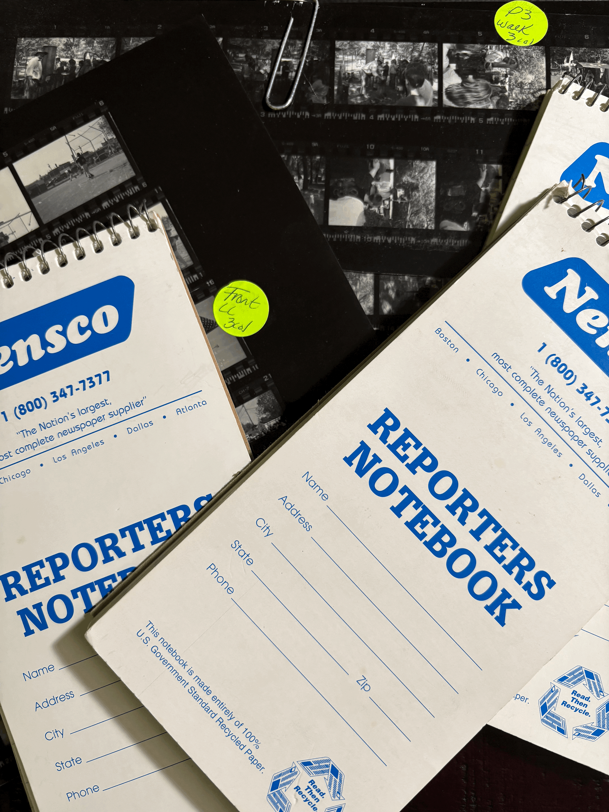A photo of old newspaper contact sheets and reporters notebooks.