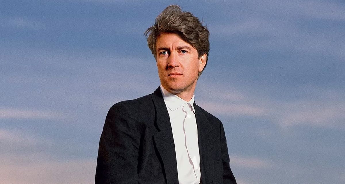 Director David Lynch stands outdoors in front of Packard vehicle in Los Angeles in 1986.