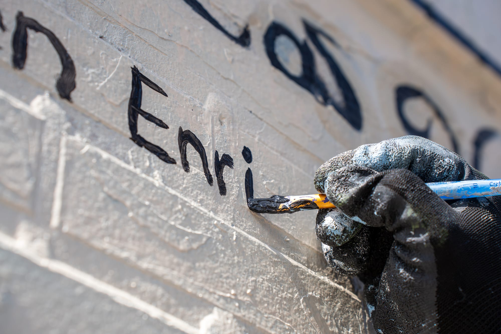 An attendee writes a name on the cancer victims list during the mural unveiling event on April 18, 2026, in Little Village. | Araceli Ramirez/15 West