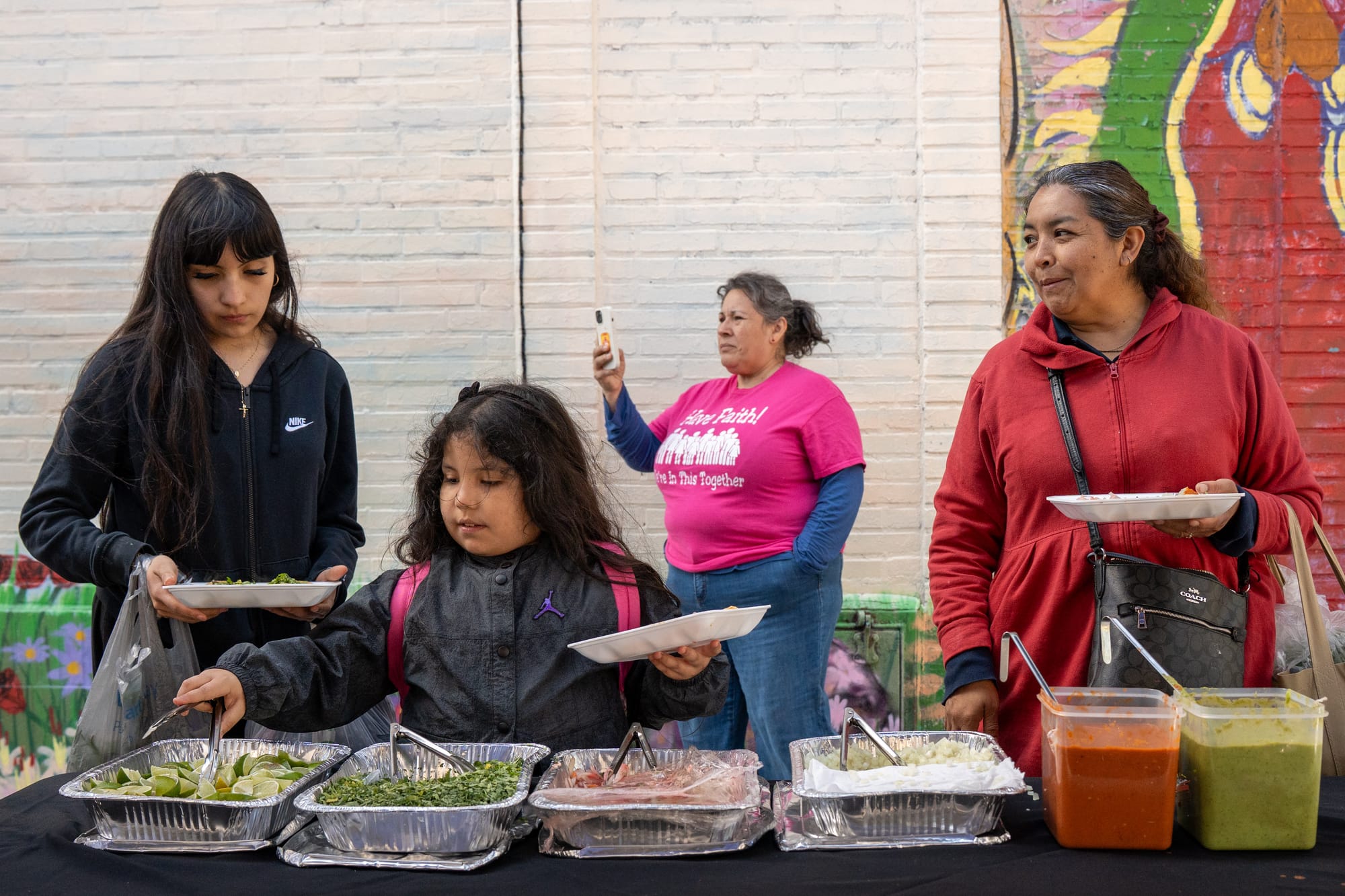 A family lines up for tacos during the mural unveiling event on April 18, 2026, in Little Village. | Araceli Ramirez/15 West
