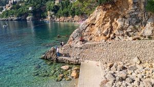 Gdje su dubrovački komunalci? Zid iznad plaže se opasno natkrivio, privatna tvrtka poslala samo dva radnika na ručnu sanaciju, a ljudi prolaze ispod odrona!