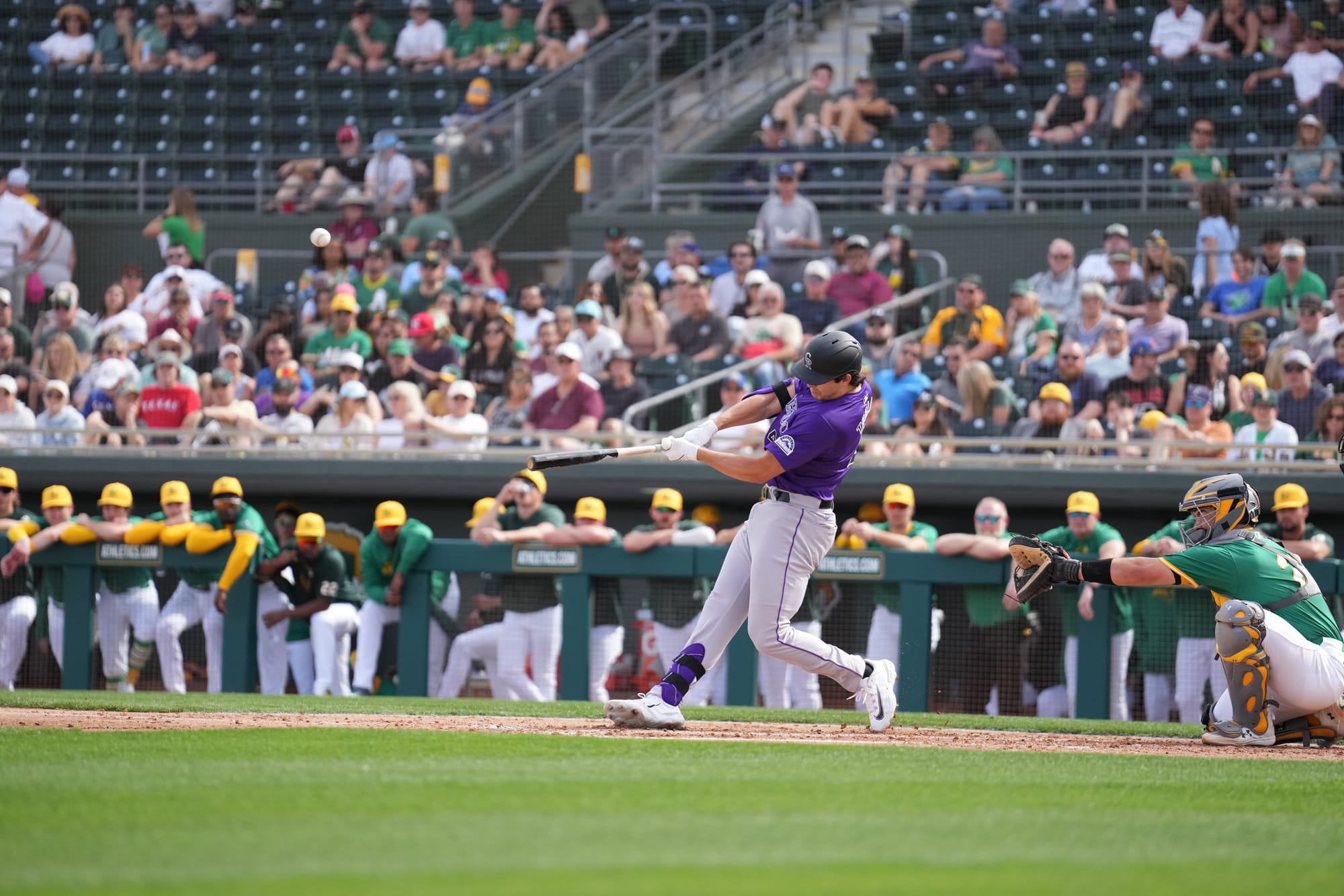 This photo shows Michael Toglia swinging from the left side of the plate. He’s wearing a purple jersey.