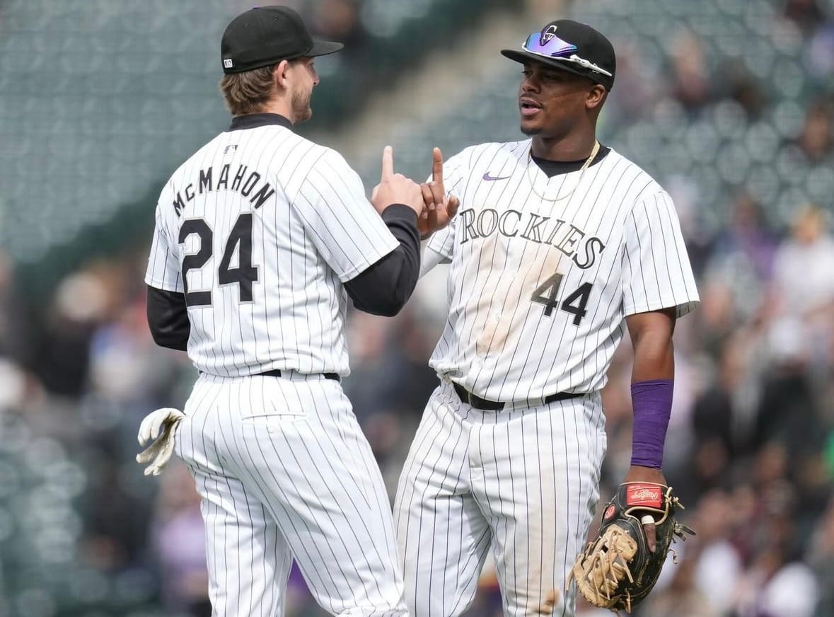 The two players tap index fingers. They’re wearing purple pinstripes.
