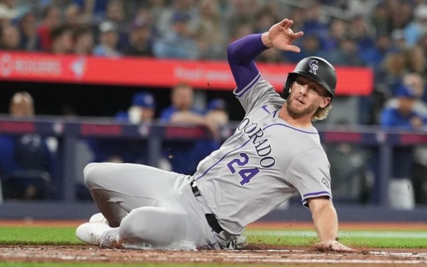 McMahon wears road grays and leans on his left hand, right in the air.