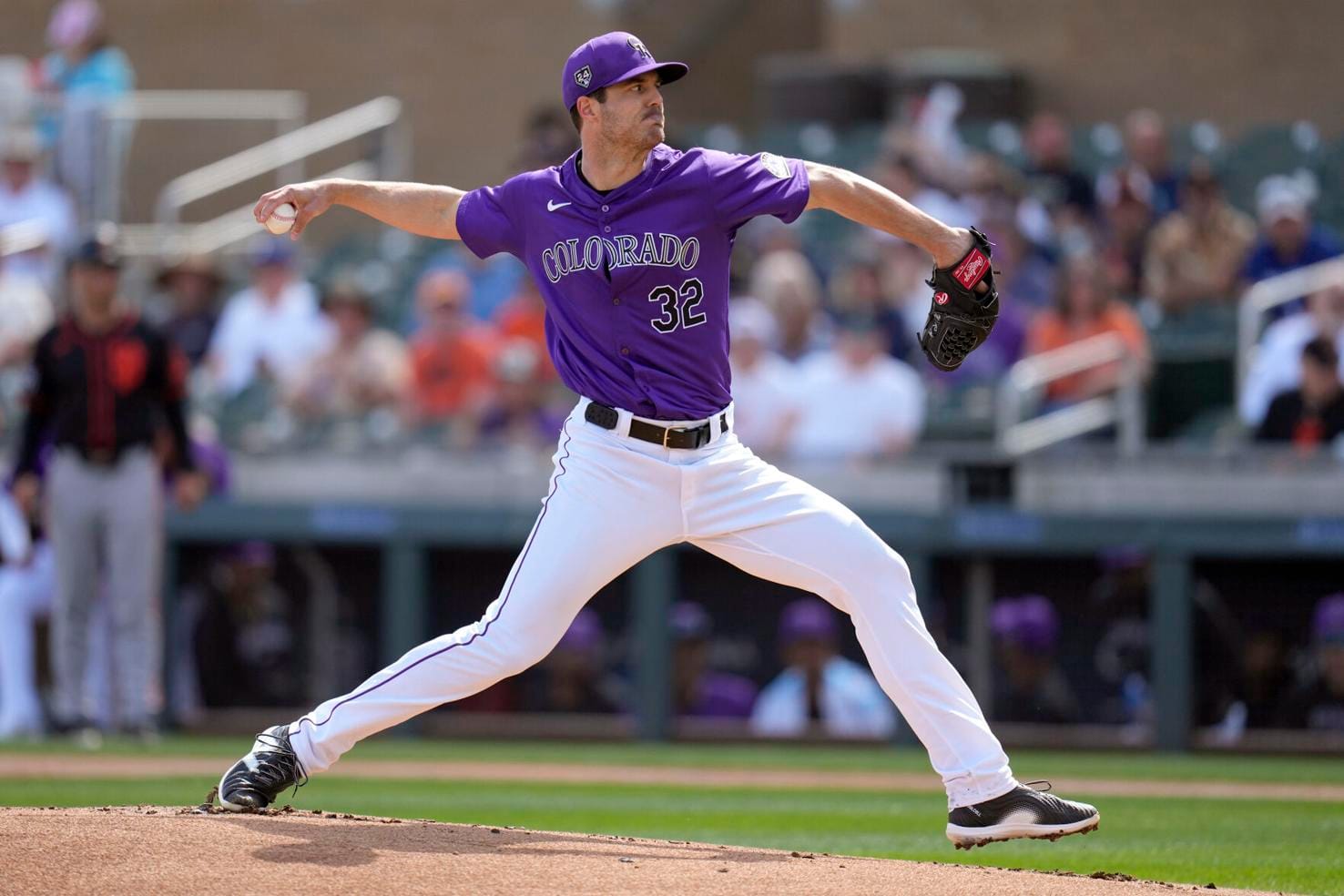 Hudson prepares to pitch. He’s wearing a purple jersey and has a black glove.