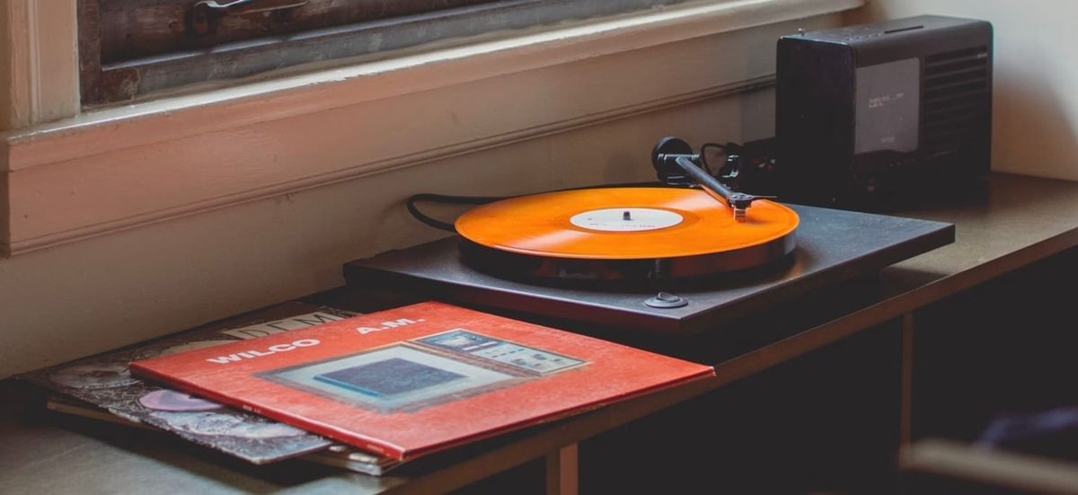 Wilco’s ”AM” album sleeve and an orange record on a record player. 