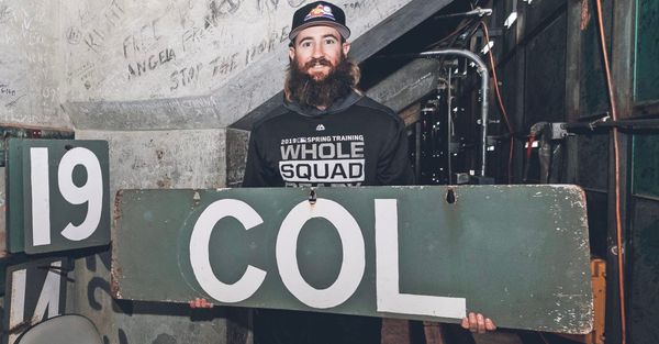 Blackmon holds a COL sign from the Fenway Park scoreboard. He’s wearing a black hoodie.