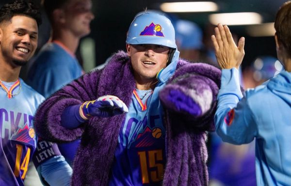 Hunter Goodman walks through the dugout in the purple home run coat.