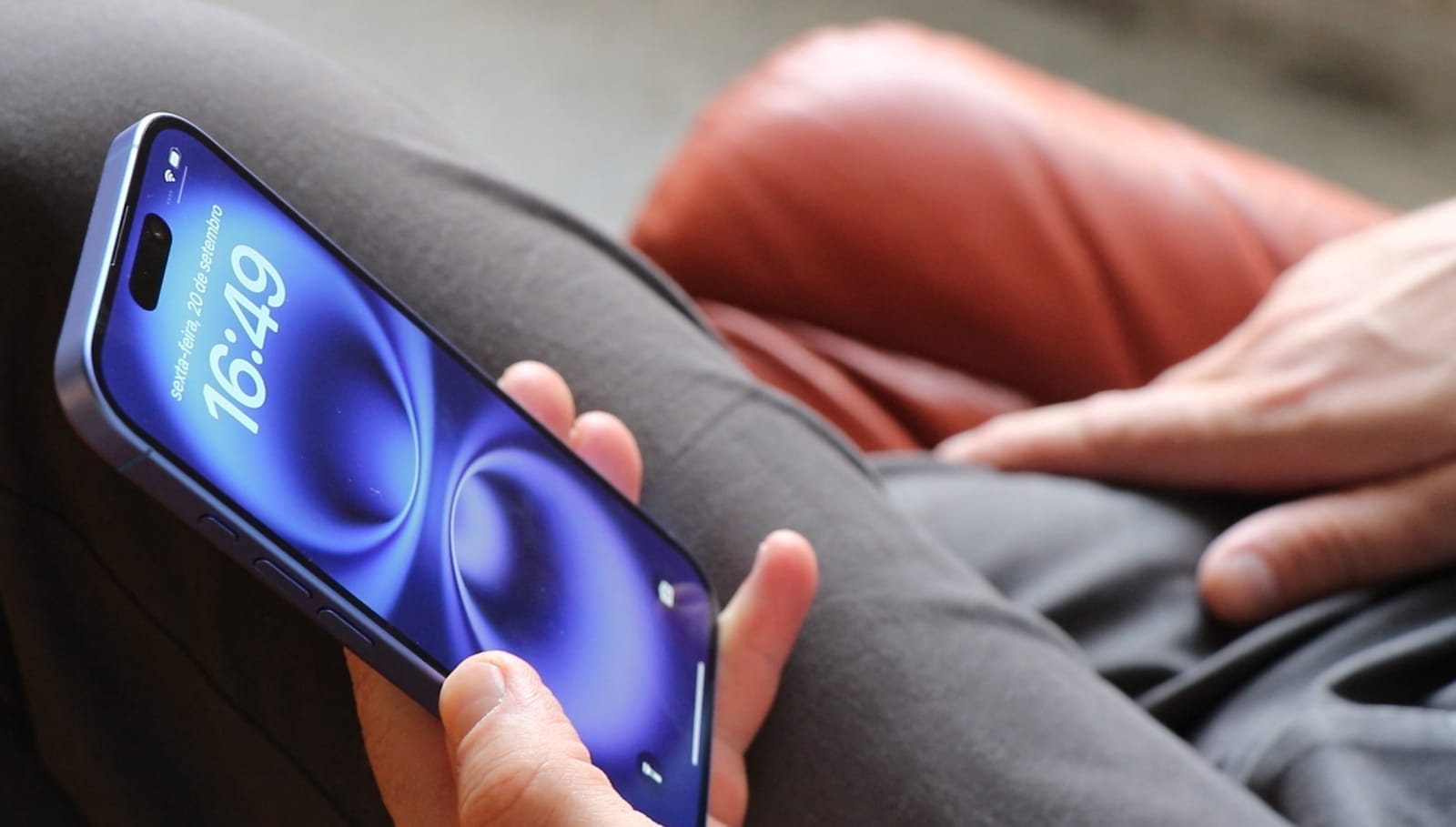 A person holding a blue iPhone in their hand