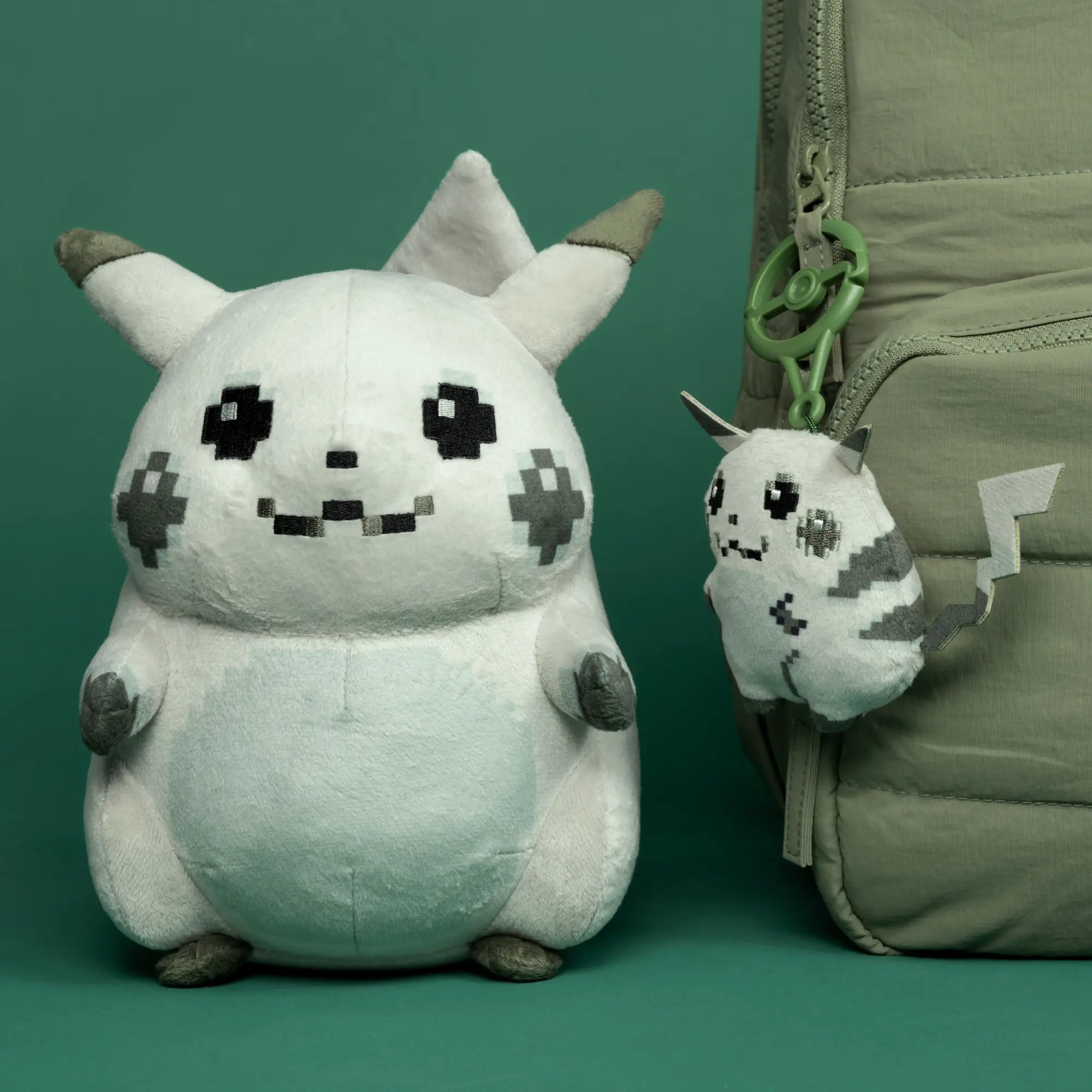 A 1996 Pikachu plush and keyring staged against a green backdrop.