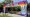 A rainbow coloured archway with 'Welcome, Trainers! May 29-June 1 Tokyo' in a park.