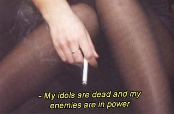 En hand som håller en cigarett, med texten: My idols are dead and my enemies are in power.