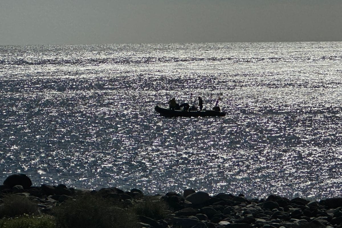 A Boat Returns To San Sebastian From Playa Del Cabrito La Gomera Also Known As Cabrito Beach Canary Islands Spain With Pebble Beach In Foreground