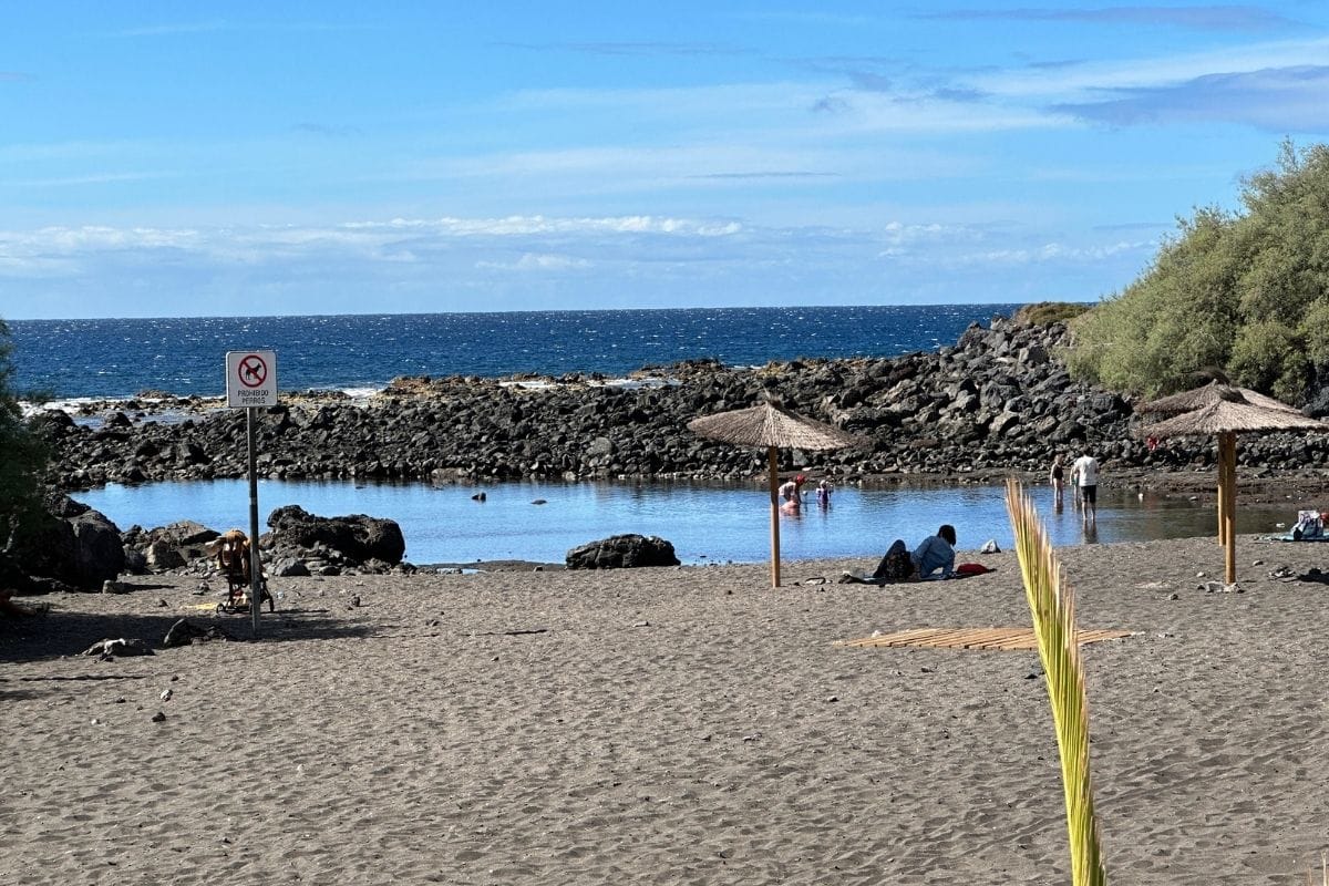 People Sit On The Beach And Swim On A Sunny Day At Charco Del Conde La Gomera At Valle Gran Rey Canary Islands Spain
