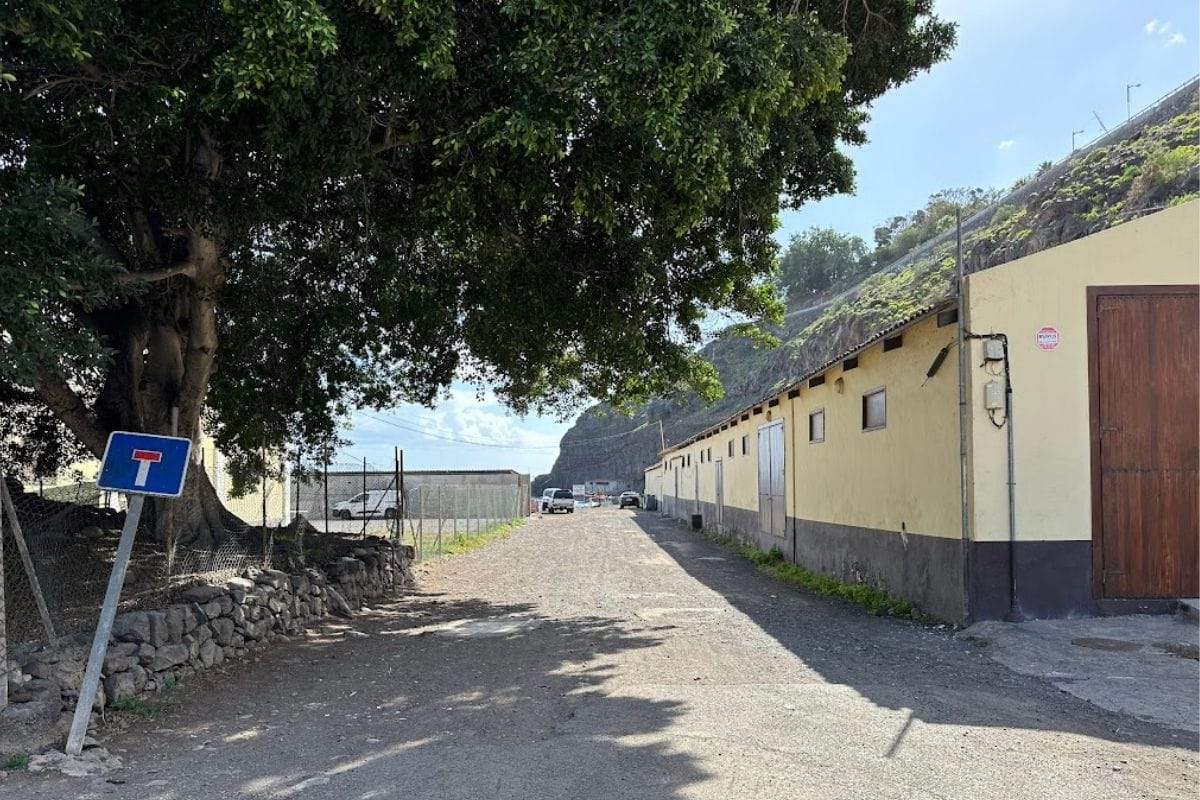 Access Road With Buildings To The Side At Playa de Tapahuga La Gomera Canary Islands Spain With Cliff In Background