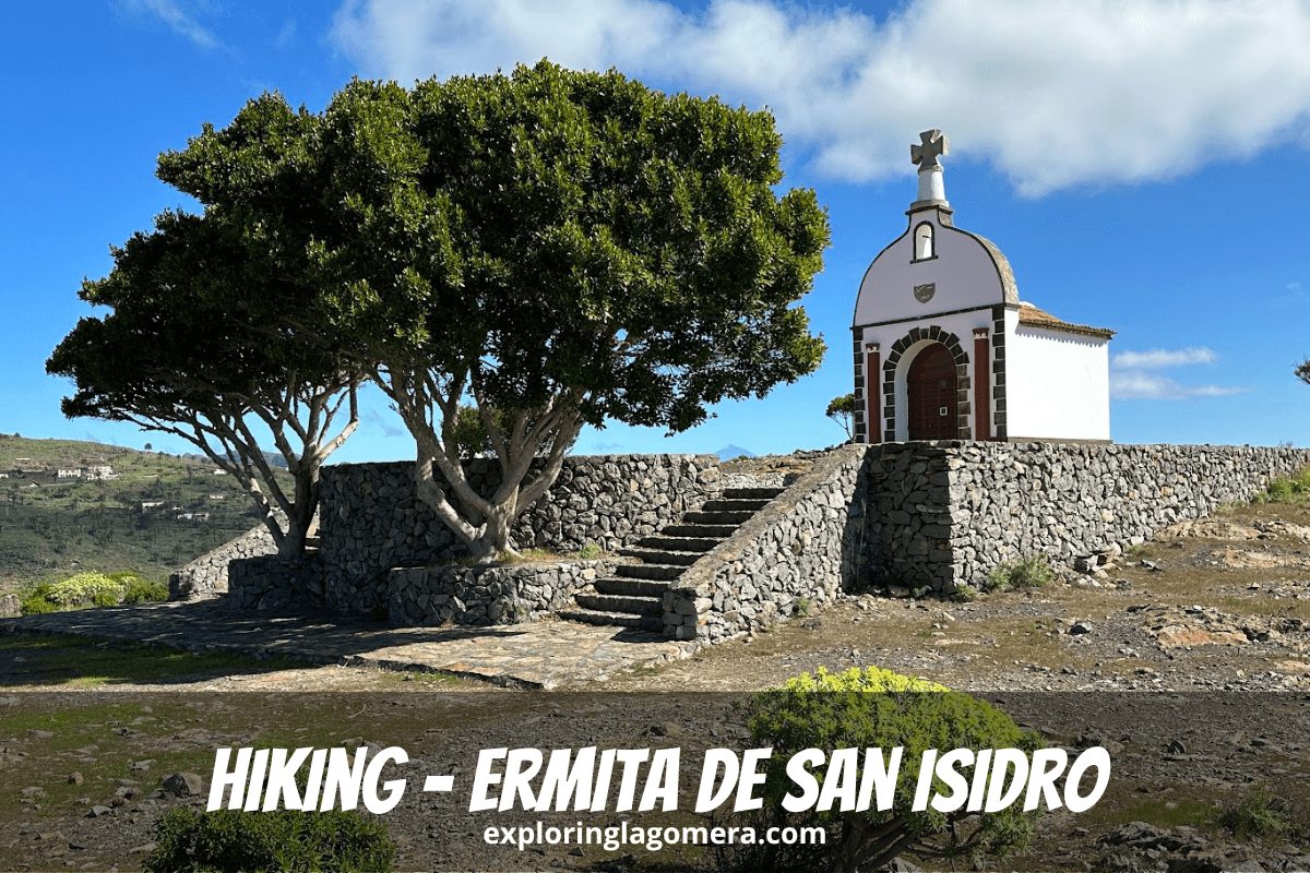 Beautiful Ermita De San Isidro La Gomera Canary Islands Spain Sits Above Stone Wall With Tree In Foreground And Blue Sky And